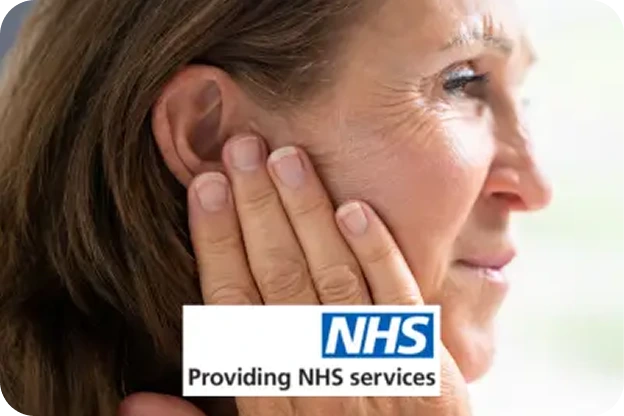 A woman holding her hand to her jaw and ear in pain